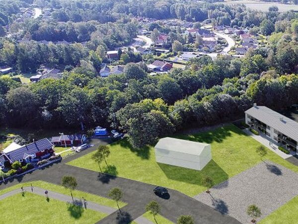 Flygbild över trädbevuxet bostadsområde med låg bebyggelse.