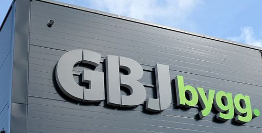 Närbild på GBJ Byggs fasadskylt med blå himmel i bakgrunden.