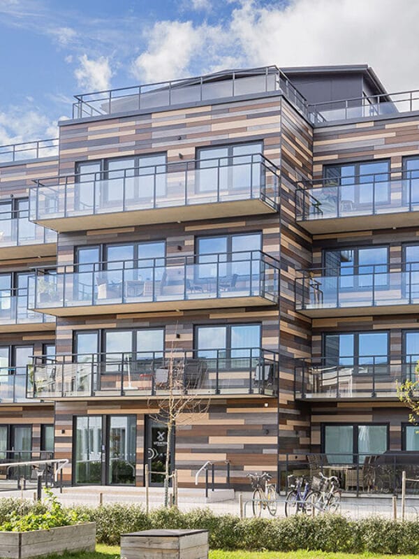 Flerbostadshus i trä och glas från GBJ bostads projekt Utsikten, beläget med närhet till havet och öppna ytor.