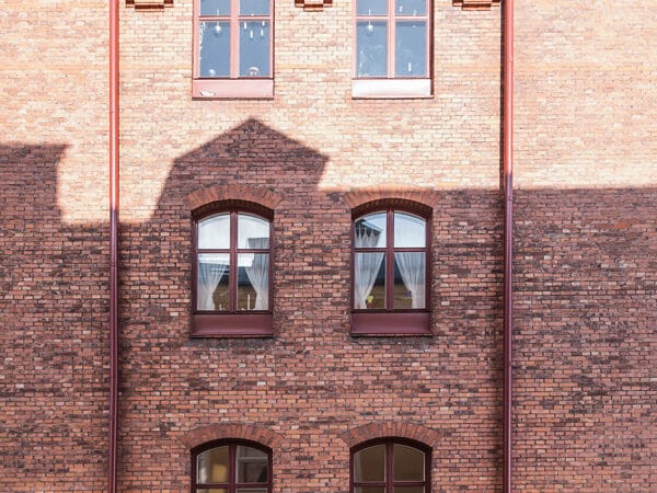 Röd tegelfasad med bågformade fönster – ett signum för Kv. Argus och en viktig del i GBJ bostads identitetsskapande renovering.