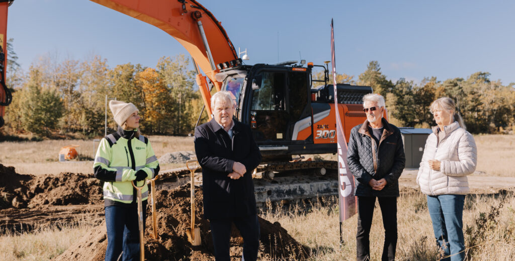 GBJ bostad markerar byggstarten för projektet Nättraby Södra Lyckan, där representanter står samlade vid ett symboliskt första spadtag framför en grävmaskin från GBJ Mark, omgiven av höstfärgad natur.