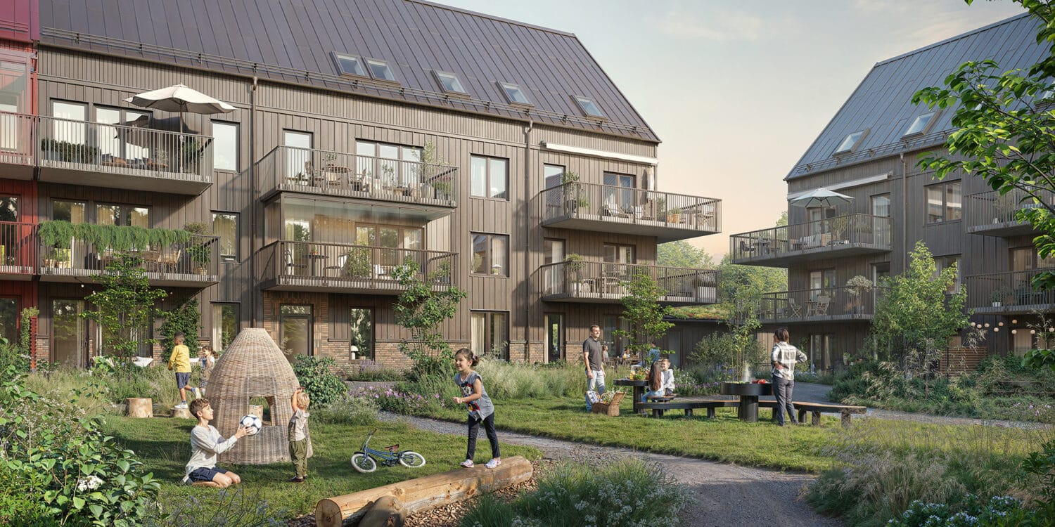 Exteriör av ängsrum i ytterby visar flerbostadshus med träfasad och balkonger där människor rör sig och umgås på innergården, omgiven av grönska och gångvägar, en trivsam boendemiljö utvecklad av GBJ bostad.